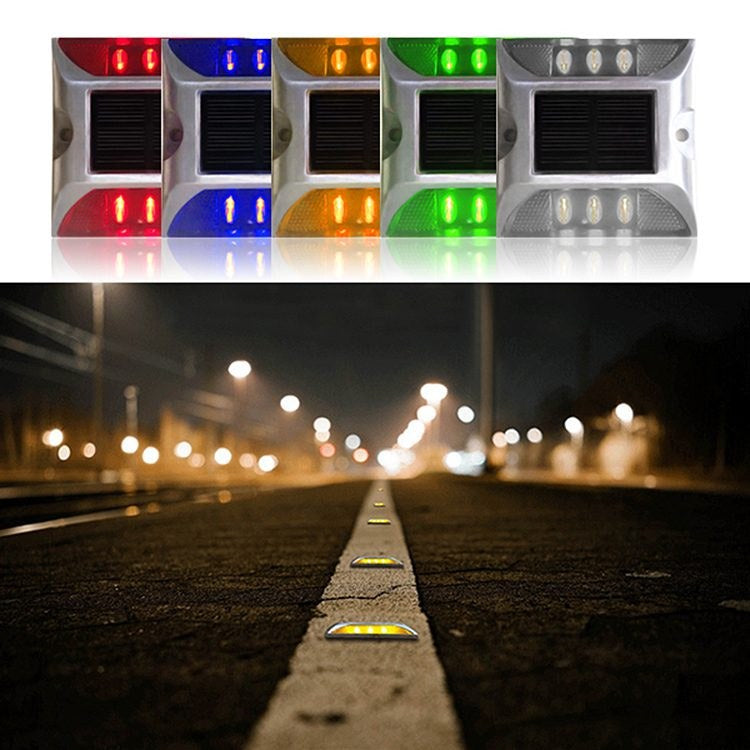 Low-profile yellow solar road stud on a kerb edge