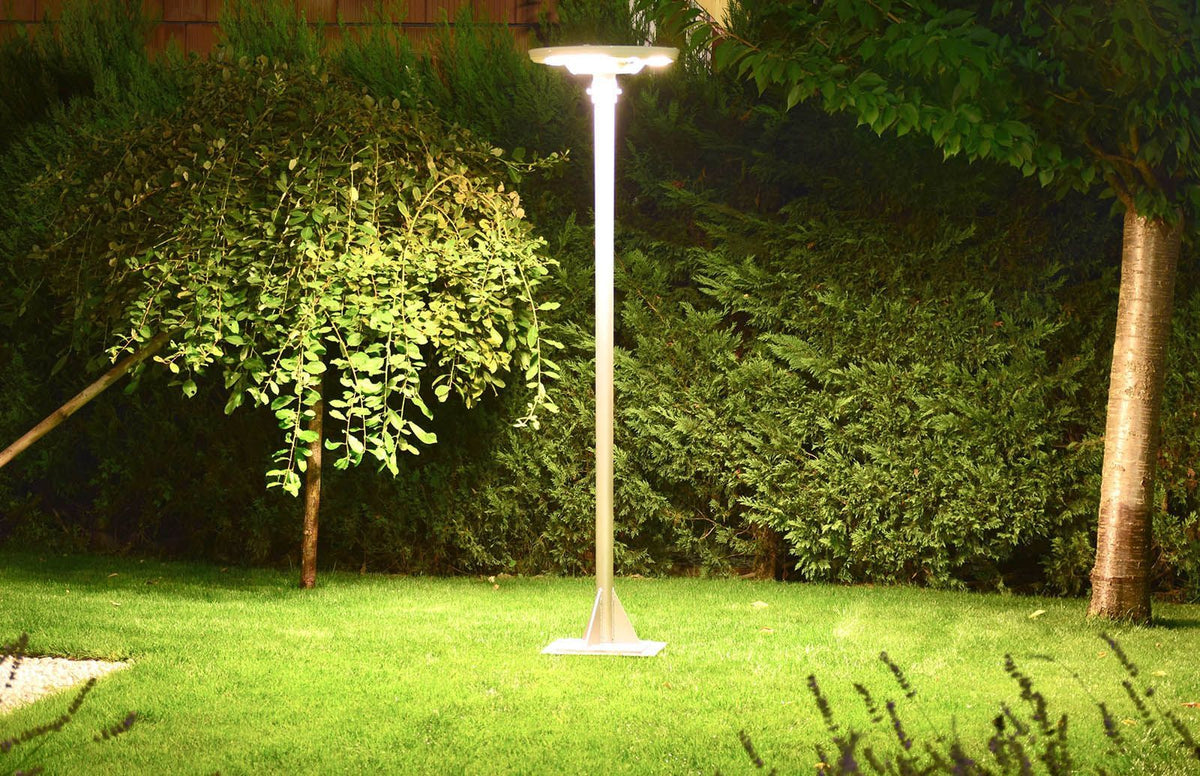EVIEKO EV-PZ-104 UFO solar plaza light – lit at night on a lawn