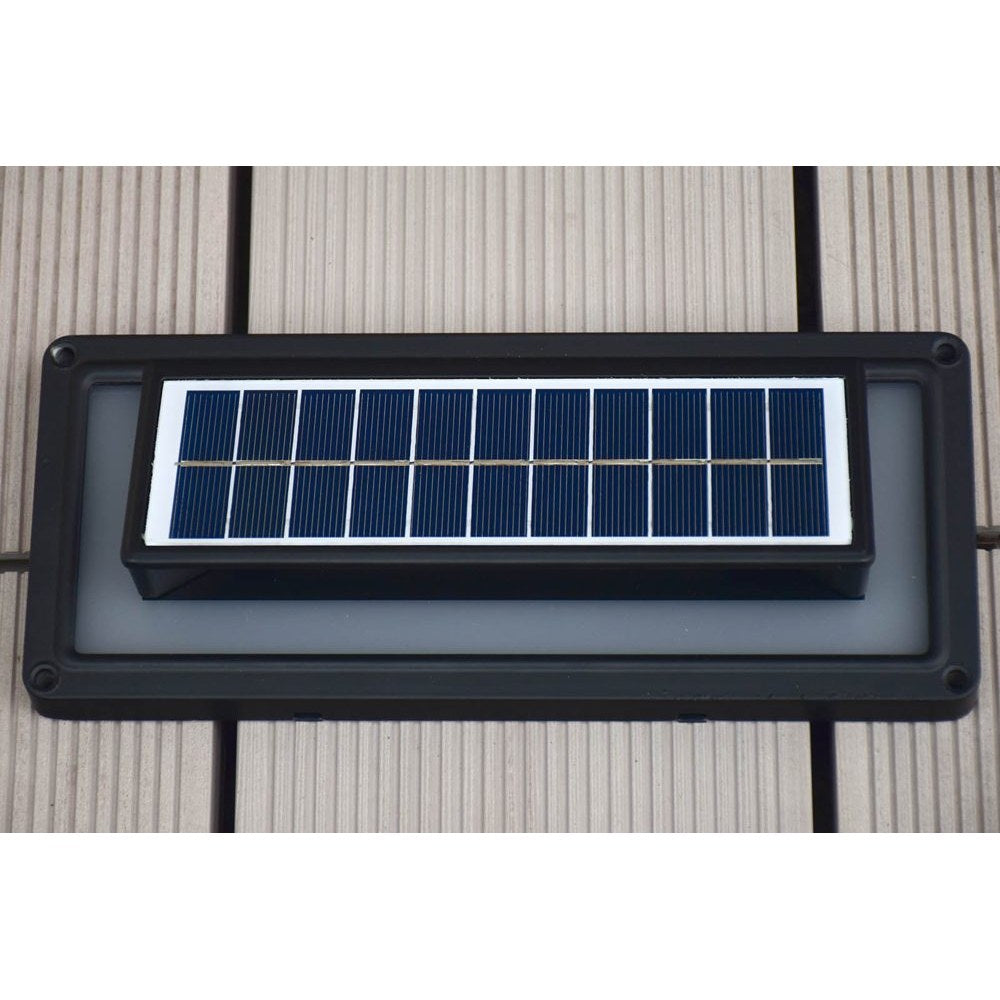 Aluminium solar wall light casting steady white light on an exterior wall