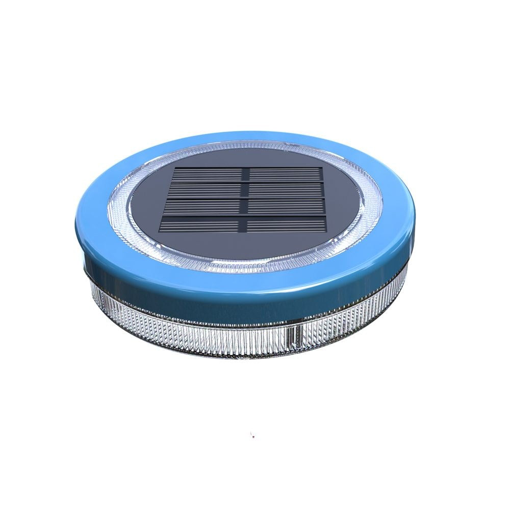Mini floating solar pool light glowing warm white on water at night