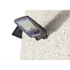 Solar flood light with detachable solar panel and PIR sensor on a shed wall