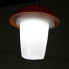 Small portable solar lantern glowing warm white on a camp table