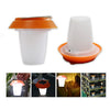 Small portable solar lantern glowing warm white on a camp table