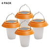 Small portable solar lantern glowing warm white on a camp table