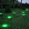 Round solar deck light glowing warm white on timber decking