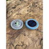 Colour-changing solar lawn light glowing blue in a garden bed