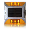Low-profile yellow solar road stud on a kerb edge