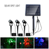 Three aluminium solar spot lights with shared solar panel lighting a garden