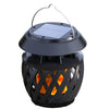 Solar flame-effect table lamp glowing on an outdoor dining table